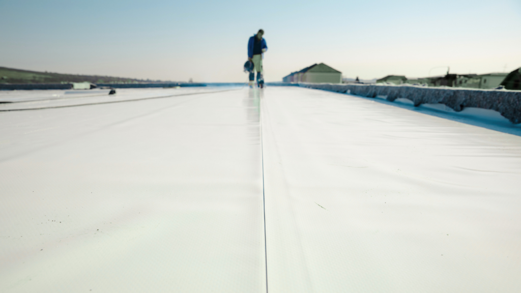 Commercial roofer on tip of roof