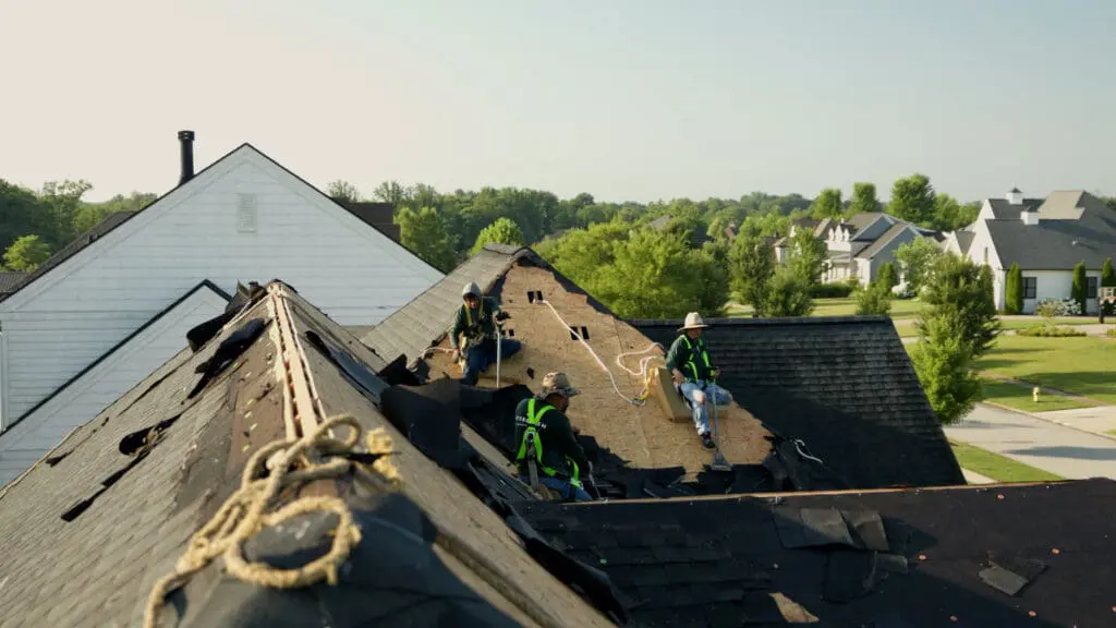 Roofers removing an old roof and putting on a new one